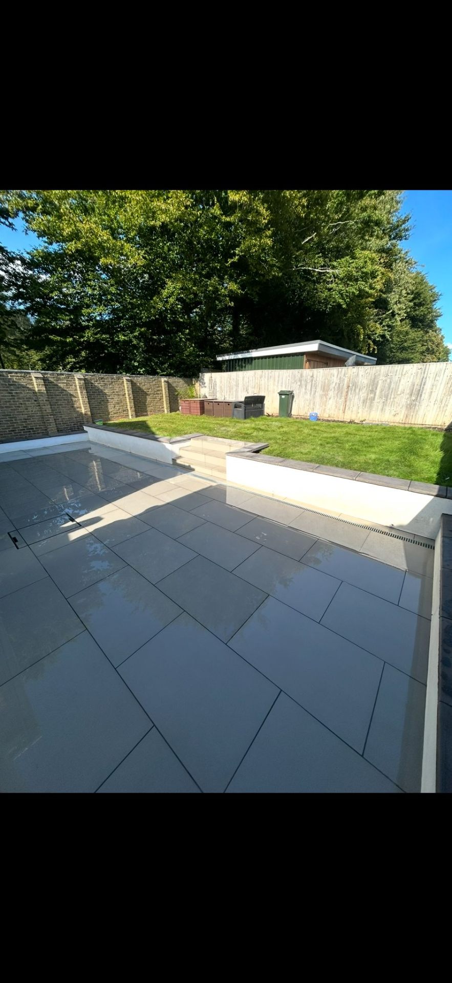 Large patio area beside home extension by Burton Builds
