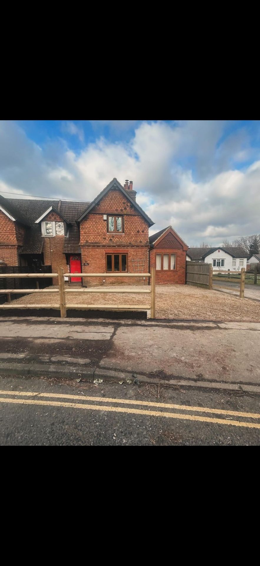 Gravel driveway with post and rail fencing by Burton Builds